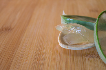 Aloe vera cut on top of a wooden table and spoon