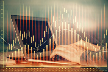 Double exposure of stock market graph with man working on laptop on background. Concept of...