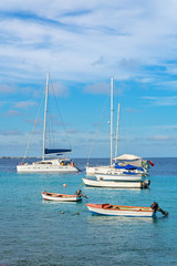 Fototapeta na wymiar Group of sailing boats on blue ocean at coast