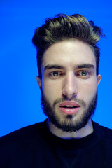 Beautiful caucasian young man portrait isolated on multicolored neon light backgroud. Young, smiling, surprised, screaming. Human emotions, facial expression concept. Trendy colors.Advertising concept