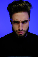 Beautiful caucasian young man portrait isolated on multicolored neon light backgroud. Young, smiling, surprised, screaming. Human emotions, facial expression concept. Trendy colors.Advertising concept