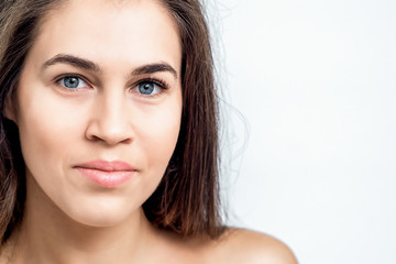 Obraz premium Portrait of a beautiful woman's natural makeup face and naked shoulders with clean skin on white background with copy space.