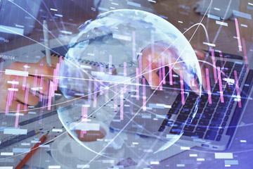 Forex graph with businessman working on computer in office on background. Concept of hardworking. Double exposure.