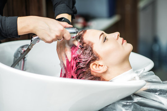 Hairdresser Washing Pink Dyed Hair Of Woman In Sink, Close Up.