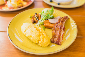 Omelette with sausage bacaon ham with vegetable in plate