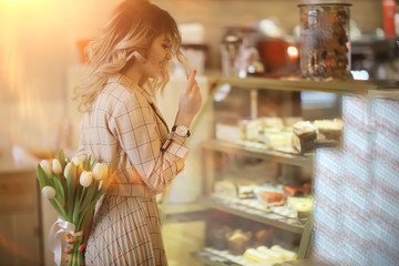 girl with a bouquet of flowers in a cafe / beautiful showcase, diet, happiness, mood