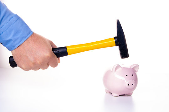 Male hand smashes a pink pig piggy bank with a hammer on a white background. The concept of savings and savings, financial management - Powered by Adobe