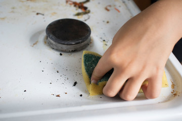Cleaning a gas stove with kitchen utensils, household concepts, or hygiene and cleaning.