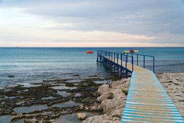 Fototapeta premium Old wooden pier leading to the sea on Cyprus.