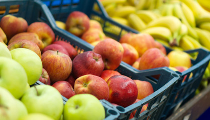 Fruit baskets in the market. Bananas and apples.
