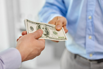 business, people and finances concept - close up of businessmen's hands holding american dollar money