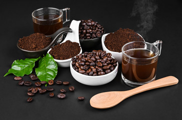 Fresh raw organic coffee beans with ground powder  on black.