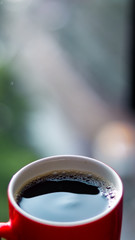 Close up of a cup of coffee in red mug