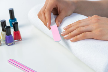 Obraz na płótnie Canvas Woman using nail file and create nails shape
