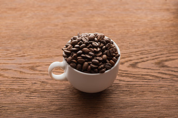cup of fresh roasted coffee beans on wooden table