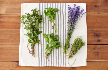 gardening, ethnoscience and organic concept - bunches of greens, spices or medicinal herbs on kitchen towel