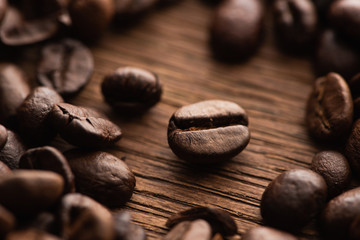 close up view of fresh roasted coffee beans scattered on wooden table