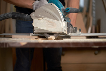 Carpenter sawing wooden boards with jigsaw