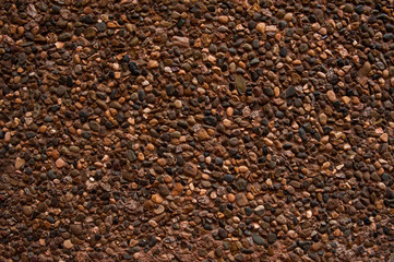 Abstract background. The rough texture, brown concrete wall is decorated with colorful decorative...