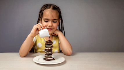 Girl pouring liquid hot chocolate on a pile of different chocolate pieces