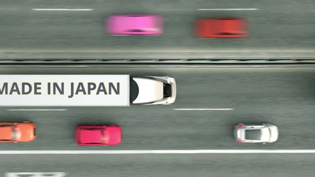 Trailer trucks with MADE IN JAPAN text driving along the road. Japanese business related loopable 3D animation