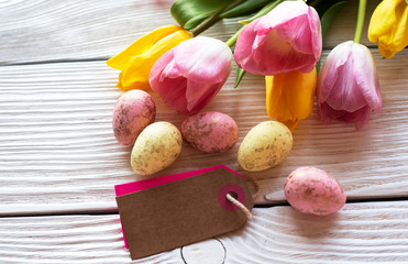 Easter eggs and tulips on a wooden background