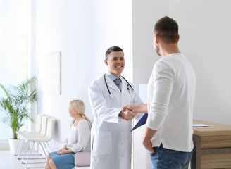 Obraz premium Doctor and patient shaking hands in hospital hall