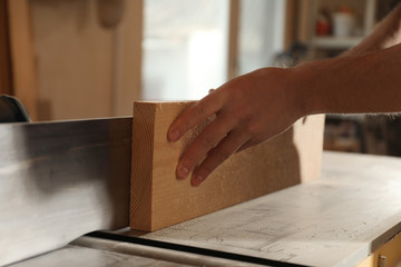Professional carpenter working with wood in shop, closeup