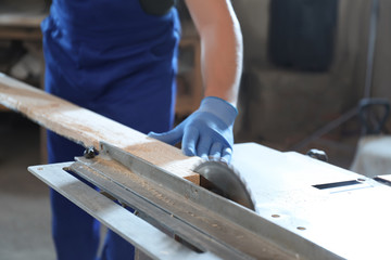 Professional carpenter working with wood in shop, closeup