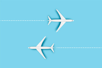 Naklejka premium Two Airplanes and a line indicating the route on a blue background. Concept travel, airline tickets, flight, route pallet. Banner. Flat lay, top view