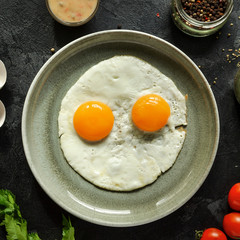 Scrambled eggs for breakfast. Perfect fried eggs in a gray plate. Ingredients. Top id. Dark background.