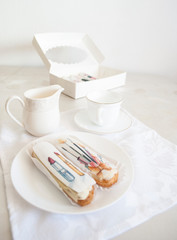 colored glazed eclairs on a white festive table with a box