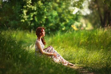 The red-haired girl walks in the forest