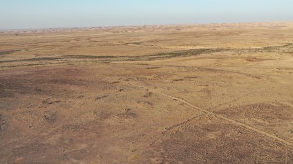 Aerial view of Negev desert landscape, Ezuz village, Israel on the border with Egypt. Hot sunny day. Blue sky, sand.
