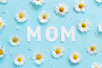 White daisies and text MOM on a light blue background