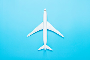 Naklejka na ściany i meble Toy airplane on a blue background. Concept travel, airline tickets, flight. Flat lay, top view