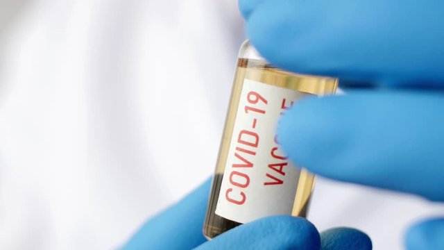Medical doctor or laborant holding tube with nCoV Coronavirus vaccine for 2019-nCoV COVID virus. Novel Coronavirus originating in Wuhan, China. Coronavirus 2019-nCoV COVID concept.