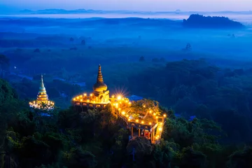 Fotobehang Khao Na Nai Luang Tham Park. Pagoda at sunrise on the top at Khao Na Nai Luang Dharma Park with fog. Beautiful Temple at Surat Thani province, Thailand. © Thirawatana
