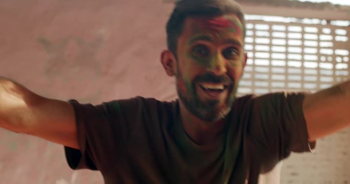 Young healthy white European tourist man, smiling, happy, enjoying himself, dancing to music in bliss loving it as he enjoys the traditional Indian festival of Holi in Rajasthan, close-up 60fps
