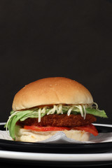 Chicken burger with salad in black background