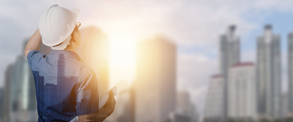 engineer holding blueprint with construction building background, working and builder concept