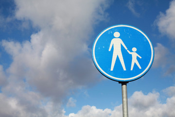 A circular, blue white road sign in the Netherlands indicating only pedestrians are allowed on the clouds background