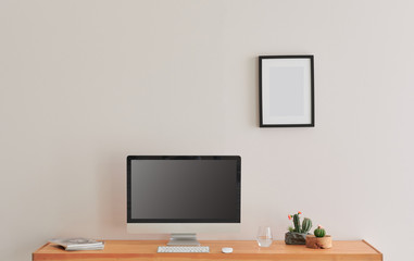 Close up television screen on the wooden table and white wall background, frame and vase of plant.