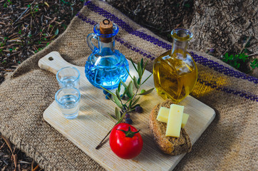 Cretan food with virgin olive oil, olives ,Cretan Barley Rusks, local cheese and carafe of cretan raki. - obrazy, fototapety, plakaty