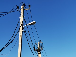 New electric blue shield with black wires on a background of clear sky on a sunny day. High voltage...
