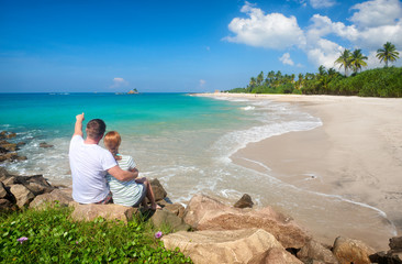 Couple tourists resting during summer vacation on beach of island Sri Lanka.