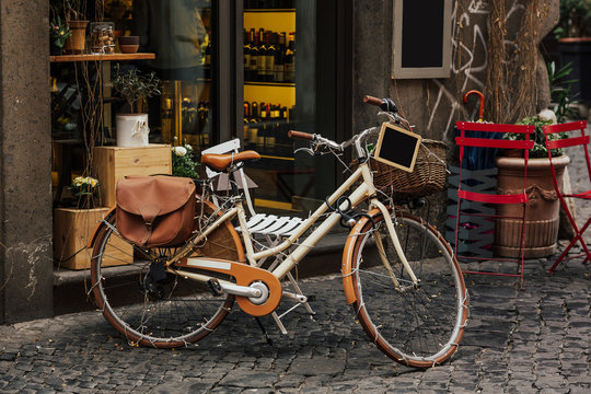Fototapeta Bicycle next to a restaurant, pretty streets of small italian villages. Vintage old bike - charming street decoration. Artwork in retro style. Copy space.