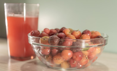 Fresh fruits and acerola juice on a wooden surface