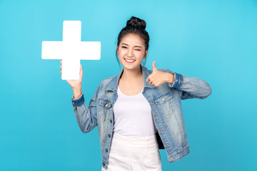 Happiness asian woman smiling, showing plus or add sign and thumb up or like on blue background....