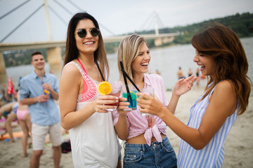 Group of young friends having fun on the beach in summer time